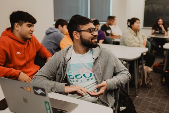 A student speaks to the room in the middle of an economics class.